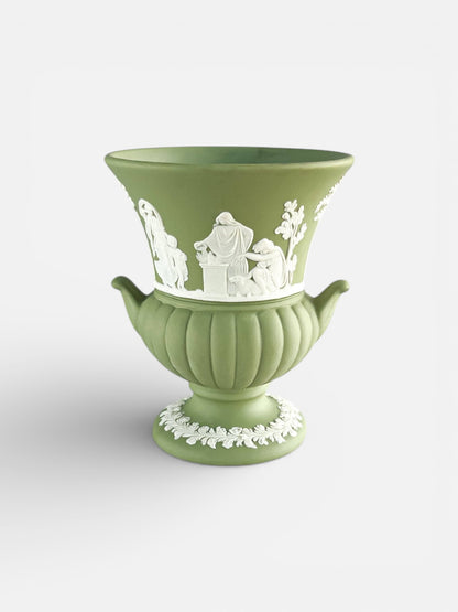 Green Wedgwood-style jasperware urn with white classical relief decorations and handles