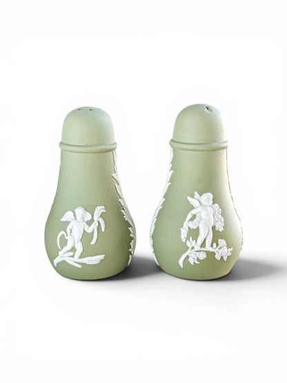 Alternate view of the vintage Wedgwood sage green Jasperware salt and pepper shakers, showcasing different classical white cherub motifs on the matte stoneware bodies.