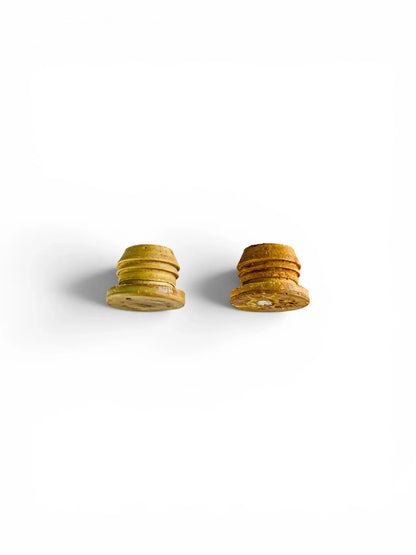 Side profile view of the two vintage ribbed Suba-Seal rubber stoppers, displaying their tapered shape and the natural discolouration and hardening that has occurred over time.