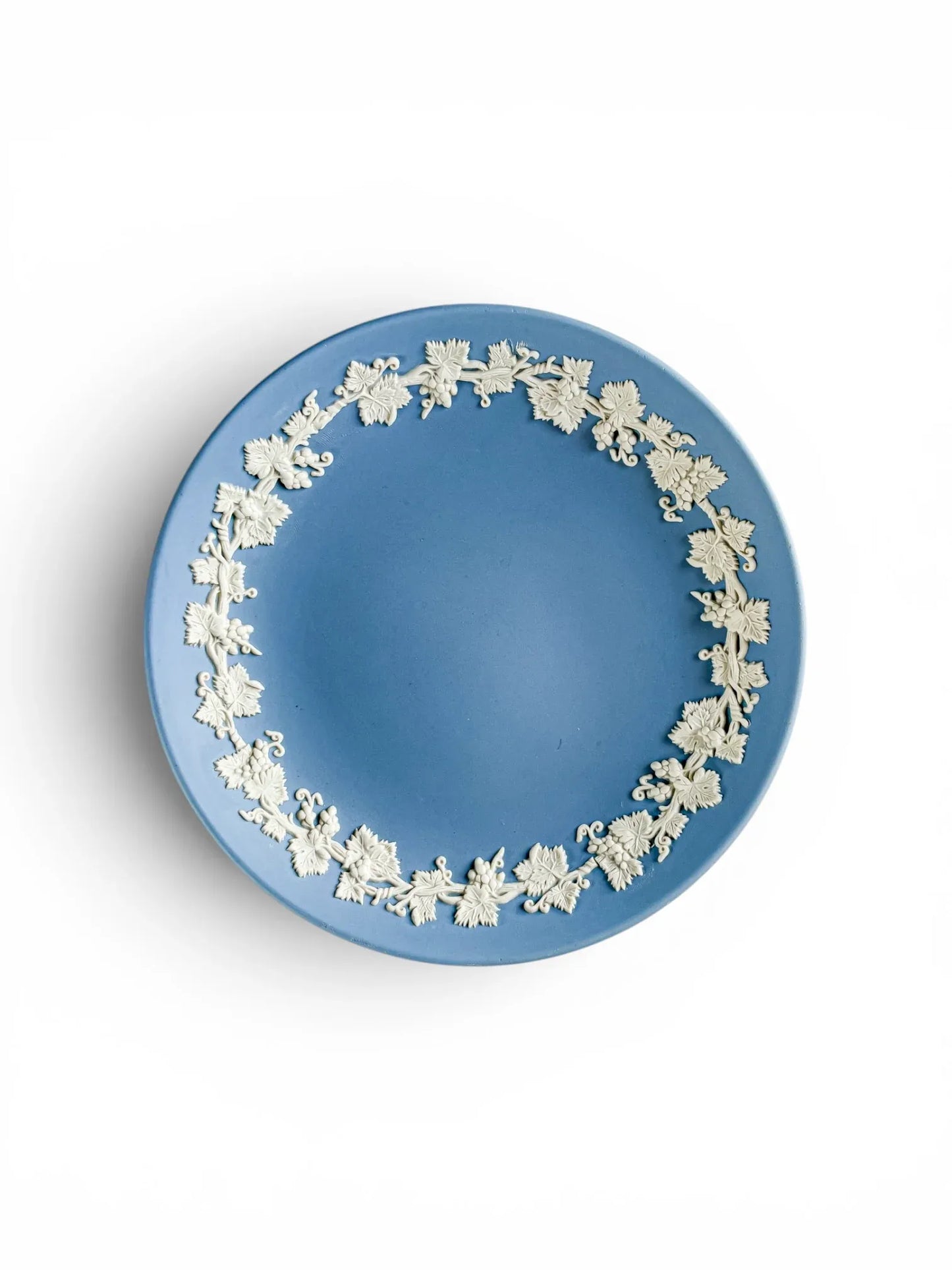 A direct top-down shot of the pale blue Wedgwood Jasperware footed compote on a white background. The image highlights the circular grapevine and leaf bas-relief border that sits perfectly on the interior rim of the bowl.
