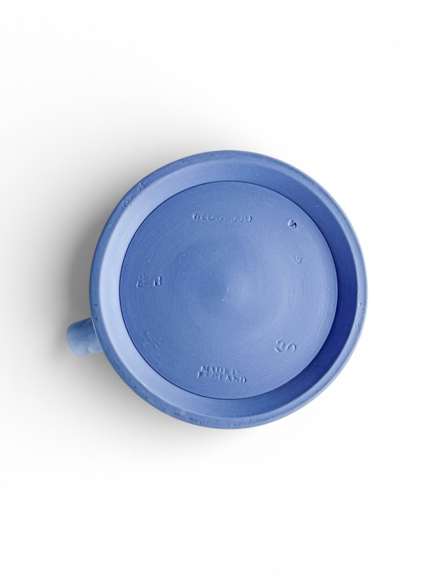 Bottom view of a Wedgwood pale blue jasperware jug with embossed markings on white background
