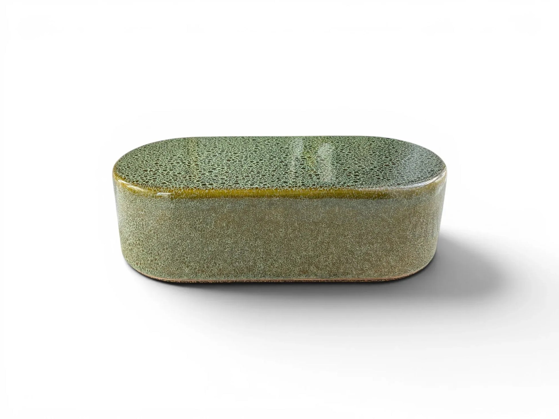 A front-angled view of a single Wiid Design rounded ceramic brick on a white background. The high-gloss reactive green glaze shows a dense, variegated "frosted" pattern, highlighting the smooth, pill-shaped silhouette of the earthenware piece.