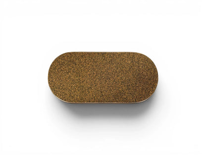 The underside of the Wiid Design ceramic brick, showing a perfectly fitted protective dark cork base. The cork provides a non-slip, soft surface to protect furniture while echoing the studio's signature material palette.