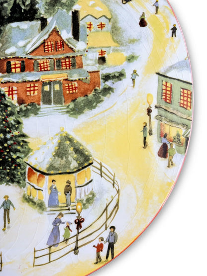 Vintage Christmas village scene with snow-covered houses, decorated tree, and people walking along snowy paths