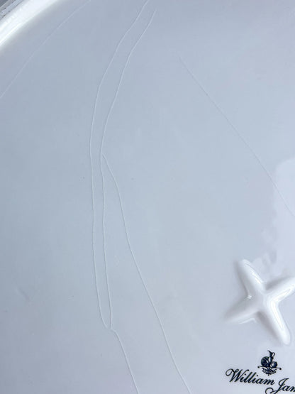 White ceramic plate with a starfish embossment and William James logo