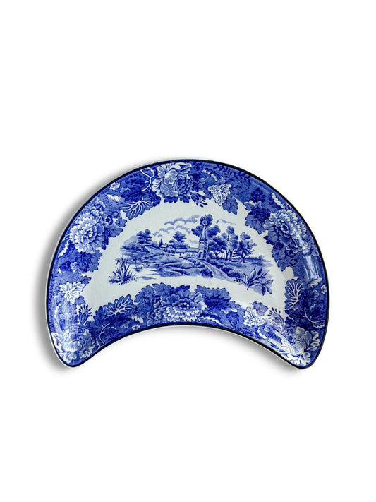 Top view of a vintage Wood & Sons 'English Scenery' crescent-shaped plate in cobalt blue and white, featuring a pastoral cottage scene.