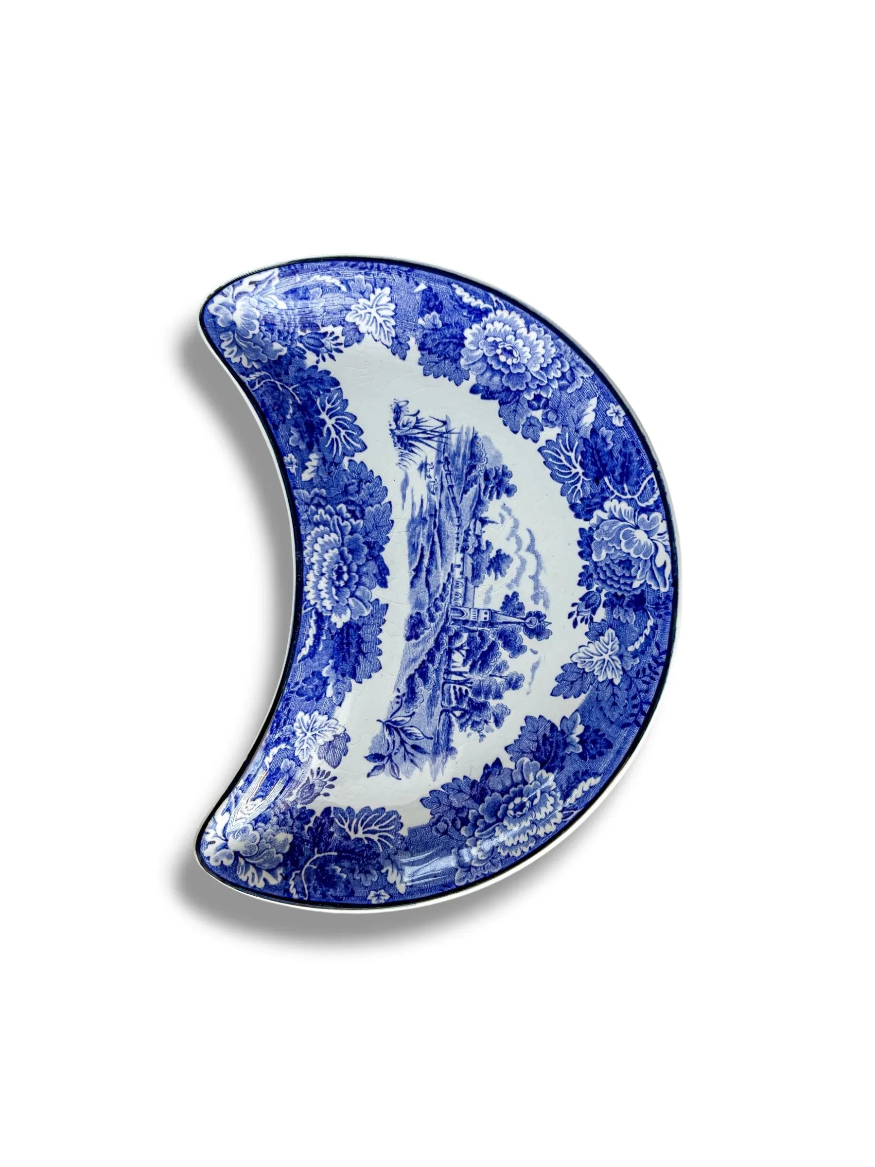 Angled view of a vintage Wood & Sons 'English Scenery' blue and white transferware crescent plate on a white background.