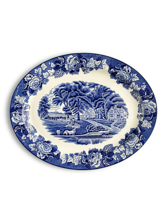 Vintage blue and white porcelain platter with pastoral scene and floral border