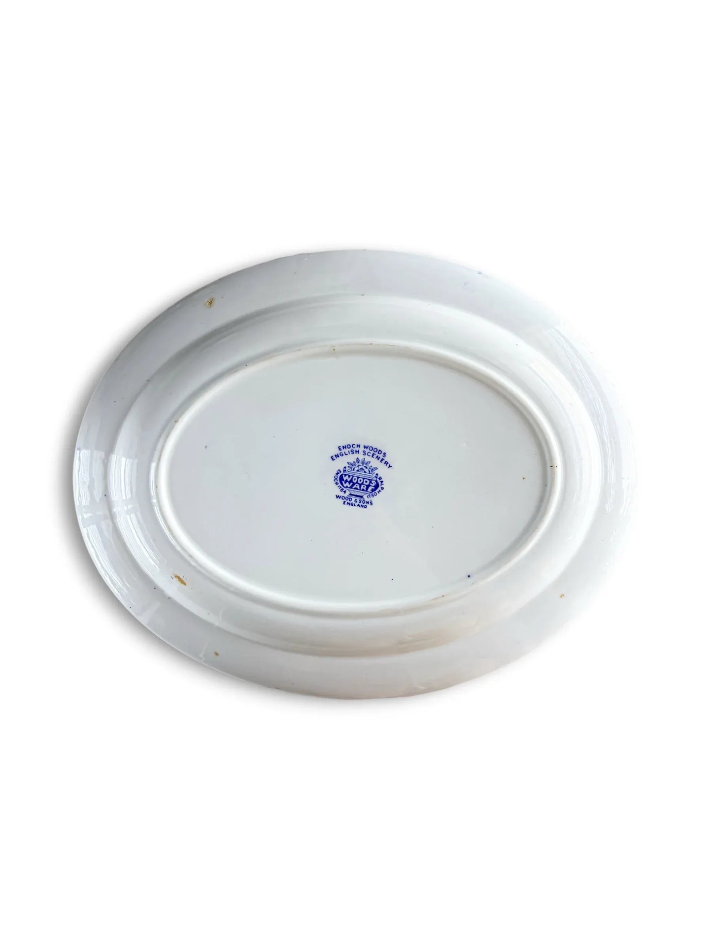 The underside of a vintage ceramic platter showing the blue Wood & Sons maker's mark. The stamp includes a crown emblem and reads "Enoch Wood's English Scenery," "Wood's Ware," and "Wood & Sons, England." The ceramic shows minor age-related discolouration spots on the rim.
