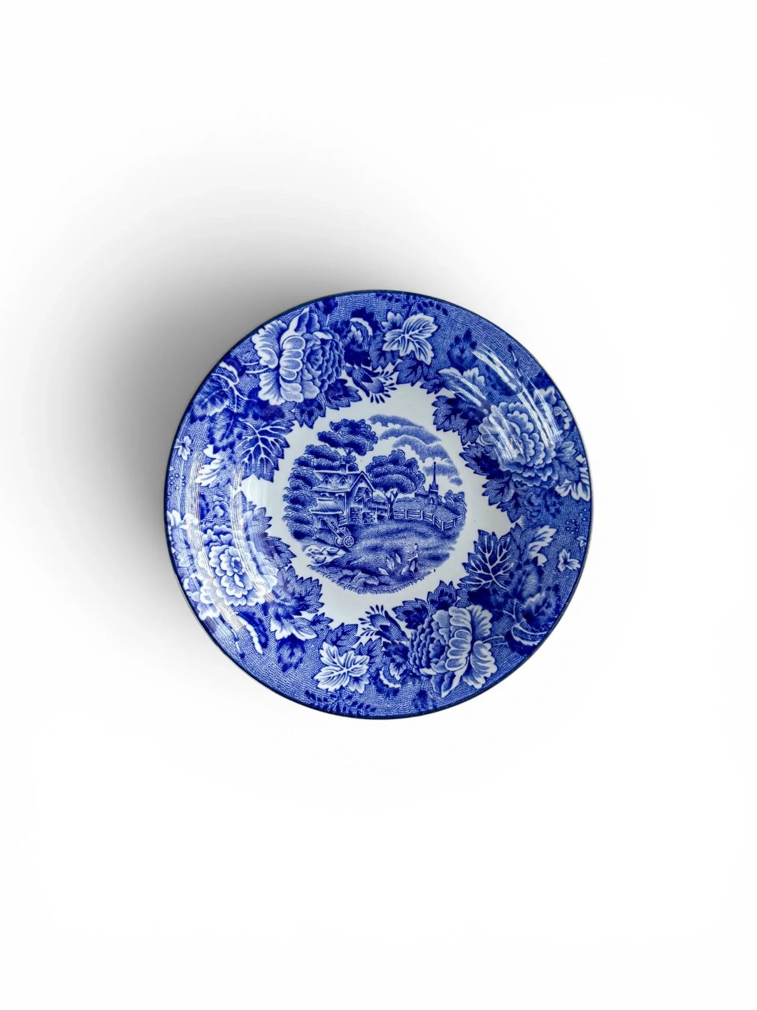 Top view of a vintage Wood & Sons 'English Scenery' small bowl, featuring a central cottage motif with a floral border in blue and white.