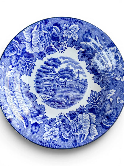 Detailed close-up of the interior pattern of a Wood & Sons blue and white transferware bowl with a crisp central cottage scene.